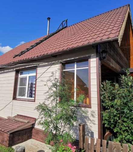 Сайдинг GRAND LINE и деревянная резьба на фасаде дачного дома.