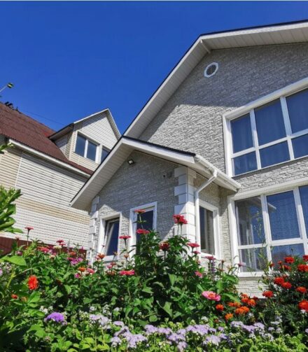 Красивый белый дом с отделкой фасадными панелями DOCKE.