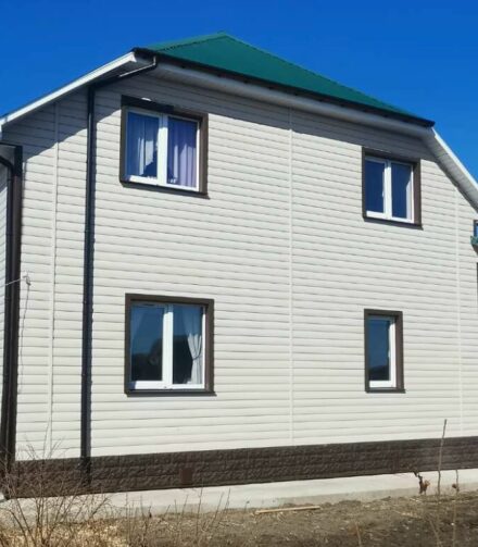 Светлый сайдинг для дома с зеленой крышей